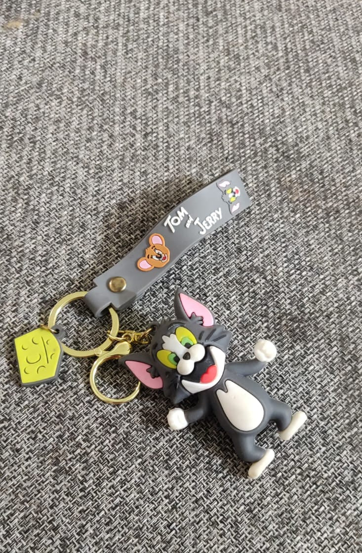Tom 3D rubber keychain on grey fabric surface