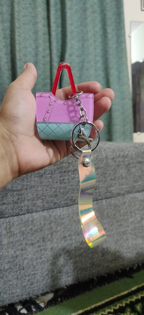 Purple and mint green mini purse keychain with holographic wrist strap close up